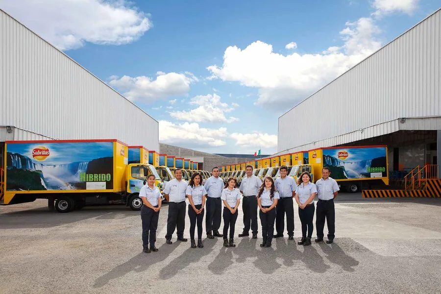Retrato corporativo — equipo de logística de Sabritas con flotilla híbrida